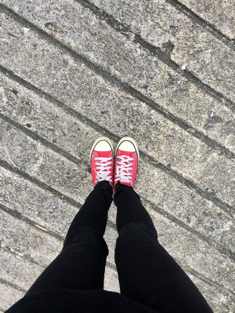 Closeup Photo of From Woman Wearing Red Sneakers On The Concrete Floor Background Great For Any Use.の写真素材
