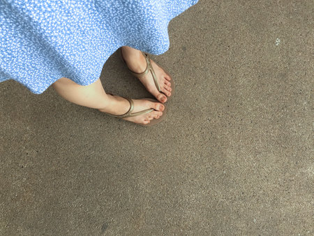 Female Feet Wear Sandals and Blue Dress on the Street Great For Any Use.