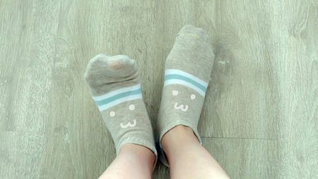 Selfie Female Legs Wear Brown Socks on a Wooden Floor Background Great For Any Use.