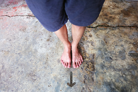 Drawn Direction Arrow, Male Barefeet on the Concrete Background Great For Any Use.の写真素材