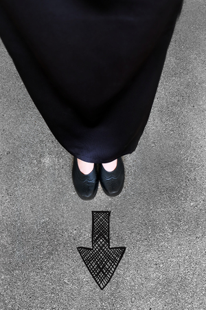 Drawn Direction Arrow, Female in Black Flat Shoes and Black Dress on the Concrete Background Great For Any Use.の写真素材