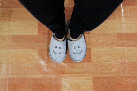Close Up of Smile Gray Slippers on Linoleum Floor Background Great For Any Use.の写真素材