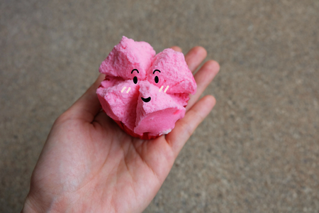 Close Up Steamed Cup Cake, Hand hold Pink Steamed Cup Cake with Smile Face on Concrete Background Great For Any Use.の写真素材