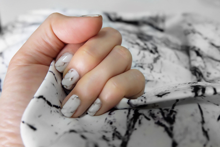 Beautiful Nail Polish, Manicure Nail. Close Up Granite Gray Nails on Fabric Background Great For Any Use.の写真素材