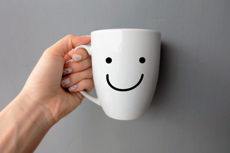 Woman Holding Happy Smile White Cup of Coffee. Close Up Granite Gray Nail Polish on the Background Great For Any Use.の写真素材