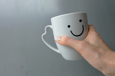 Woman Holding Happy Smile White Cup of Coffee. Close Up Granite Gray Nail Polish on the Background Great For Any Use.の写真素材