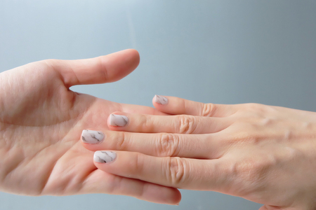 Beautiful Nail Polish, Manicure Nail. Close Up Granite Gray Nails on the Gray Background Great For Any Use.の写真素材
