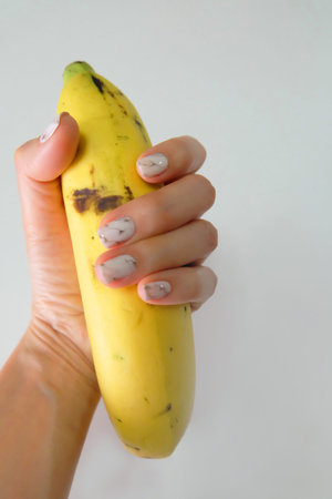 Hand holding a Banana Fruit on White Background Great For Any Use.の写真素材