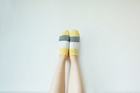 Striped Sock. Woman Slim Legs and Feet Wear Sock Striped on White Wall Background Great For Any Use.の写真素材