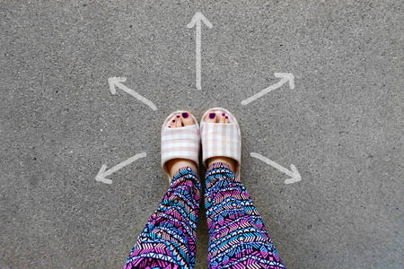Womanâs Wear Home Slippers Feet with Arrows Drawn Choices Direction on Concrete Background Great for Any Use.の写真素材