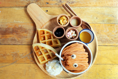 Thai Tea Shaved Ice. Milk Tea Shaved Ice Dessert with Bread and Topping Whipping Cream On Wooden Table Background Great for Any Use.の写真素材
