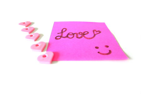 Drawn Smile Face with Love Word on Pink Sticker Paper Note on a White Background Great for Any Use.の写真素材