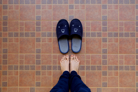 Female Legs in Blue Slippers. Woman in Smile Face Slippers Idea Concept on Tile Background Great for Any Use.の写真素材