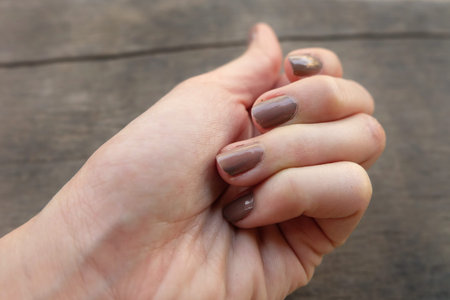 Fashion Brown Manicure Nail. Femaleâs Hand Nails Polish on the Wood Background Great for Any Use.の写真素材
