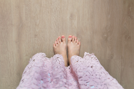 Beautiful Woman Legs and Feet. Close Up Female Barefoot On Wooden Floor Background Great for Any Use.の写真素材