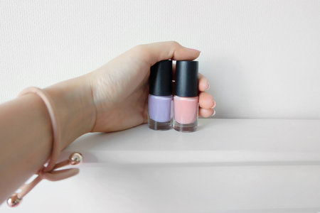 Close Up Hands with Pink Painted Nails. Beautiful Pink Nail Manicure with Pink Bottle in Woman is Hand on White Background Great for Any Use.の写真素材