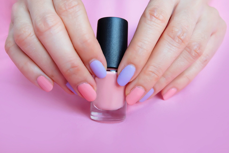 Pink Painted Nails. Beautiful Pink Nail Manicure with Pink Bottle in Woman is Hand on Pink Background Great for Any Use.の写真素材