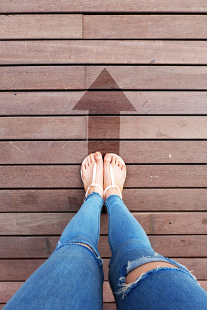 Selfie Lack of Jeans and Shoes on the Road. Sandal with Arrow Ahead on Wooden Floor Background Great for Any Use.の写真素材