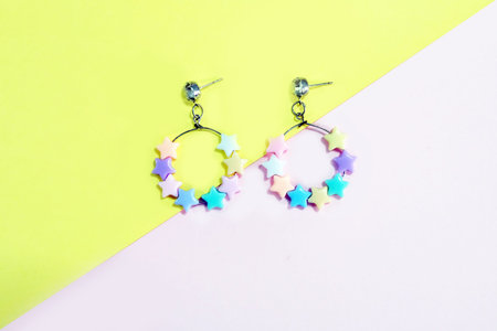 Colorful Hoop Earring Fashion Accessories. Hoop Earrings with Star Bead Isolated on Pink and Yellow...