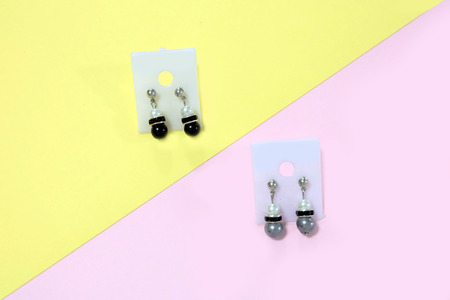 Chandelier Ear Ring for Fashion Accessories. A Pair of Drop Earrings with Gray Isolated on Yellow and Pink Pastel Background Great For Any Use.の写真素材