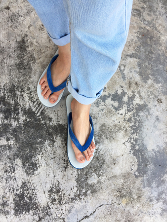 Blue Flip Flop Isolated on Cement Floor,Top view. Beautiful Woman Wearing Blue Shoes and Jeans of Accessory on Concrete Background Great For Any Use.の写真素材