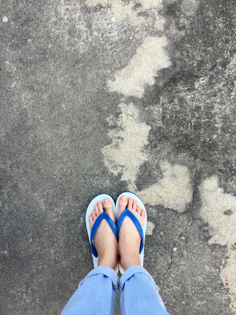 Blue Flip Flop Isolated on Cement Floor,Top view. Beautiful Woman Wearing Blue Shoes and Jeans of Accessory on Concrete Background Great For Any Use.の写真素材