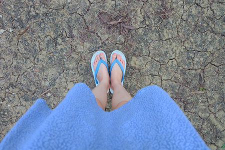 Selfie Blue Shoes Standing Isolated on Crack Soil Floor for Top View. Woman is Feet Wearing Blue...