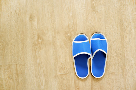 Pair of Blank Blue House Slippers Isolated from Hotel. Woman Bed Shoes, Clear Warm Sandal Over Wood...