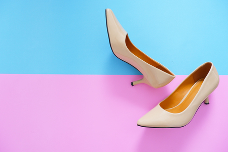 Stylish Nude Medium High-Heels Shoes Isolated on Pastel Colors. Female Sandals (Footwear) Accessory. Pair of Beautiful Woman Leather Shoe on the Pastel Pink and Blue Background, Copy space, Top View.の写真素材