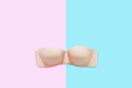 Beautiful Beige Underwear Isolated on Pink and Blue Pastel. Set of Accessory Lingerie (Bikini), Copy Space. Woman is Lace Sexy Nude or Brown Bra (Brassiere) on Two Tone Color Background, Top View.の写真素材