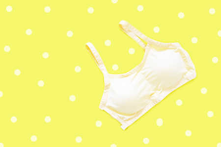 Top View of Sportswear Clothing. Women is Yellow Sports Bra Isolated on Yellow Color Pastel. Sport Accessories and Fashion, Healthy Lifestyle. Sport Clothes on Yellow Background for Pastel Wallpaper.の写真素材
