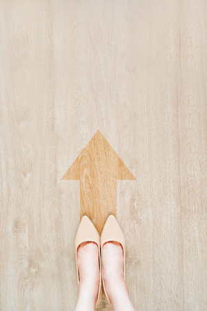Brown Arrow Choice on Road Street, Go Ahead Concept. Female Standing with Nude Sandal (Shoe). Selfie Woman Wearing Beige Medium High-Heels Shoes on Wooden Background with Arrow Line and Vintage Tone.の写真素材