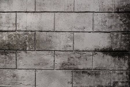 Grey brick wall, brickwork background of dark stone textured for design. Old vintage concrete block wall texture for pattern and wallpaper in rural room. Interior concept. Monochrome of rough stone.の写真素材