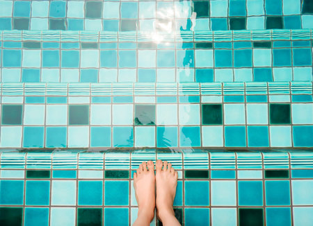 Selfie of feet and legs in green swimming pool and waves background or texture. Top view. Beautiful...