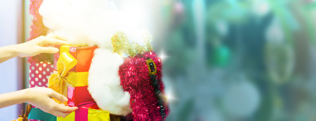 People holding hand gift box ribbon or present with red bow for birthday party holiday banner. Happy New Year and Merry Christmas party background abstract. Beauty Xmas decoration and Christmastime.の写真素材