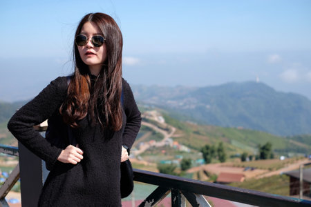 Asian woman in casual sweater of amazing landscape with mountains landscape background. Happy traveler female during vacation in Thailand.の写真素材