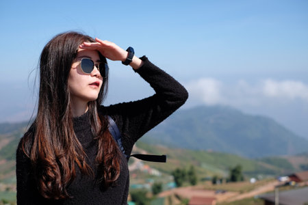 Asian woman in casual sweater of amazing landscape with mountains landscape background. Happy traveler female during vacation in Thailand.の写真素材