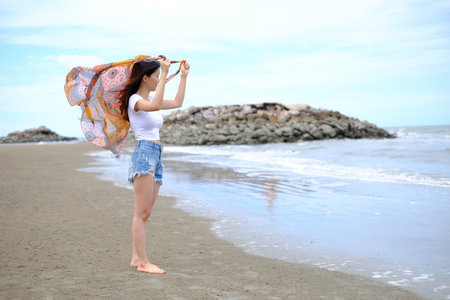 Summer beach background. Portrait young asian woman with a white shirt in vacation travel holiday.の写真素材