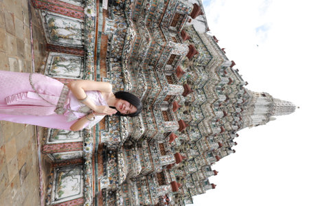 Young Asian woman in traditional Thai costumes at Wat Arun Ratchawararam (the Temple of Dawn) in Bangkok, Thailand.の写真素材