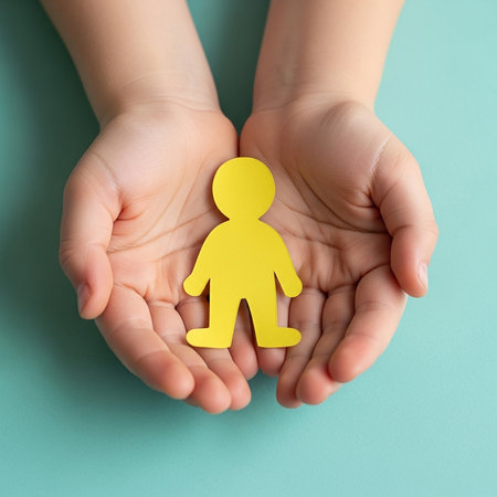 A childs open hands gently cradle a yellow paper cutout of a person, symbolizing care, protection, and the importance of human connection.の素材