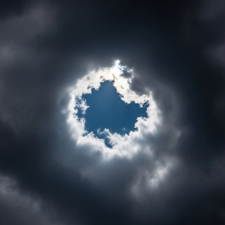 A captivating image of a hole in the clouds revealing a vibrant blue sky, surrounded by dark, ominous clouds. The contrast creates a dramatic and visually stunning scene.の素材