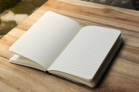Close up of empty note book on wooden table during the dayの写真素材