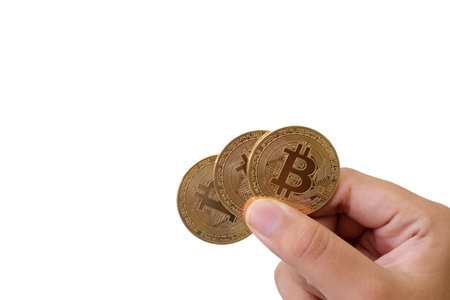 Close up of hand holding bitcoin isolated on white background. Cryptocurrency trading conceptの写真素材