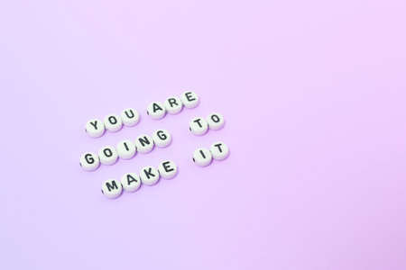 Top view of "You are going to make it" quotes made out of beads on pastel background. motivation and success conceptの写真素材