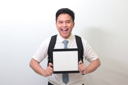 Indonesian senior high school student wearing white shirt uniform with gray tie showing empty frame. Blank space for typography or text to fill. Isolated image on white backgroundの写真素材