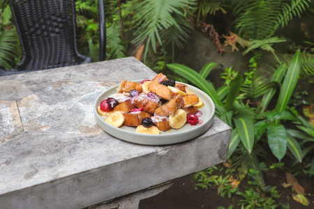 French toast with strawberry, blueberry, mixed berry, honey, and banana served on plate in outdoor restaurant table. Sweet treatsの写真素材