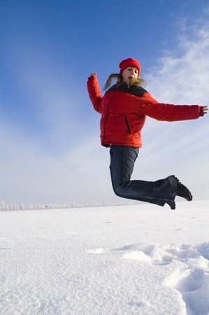 Jumping happy girl on the sky backgroundの写真素材