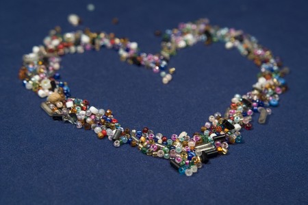 the heartbeads laying in the blue materialの写真素材