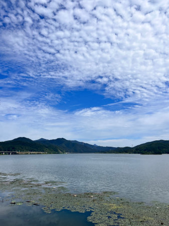 Landscape of lake and mountain under blue sky with white clouds.の写真素材