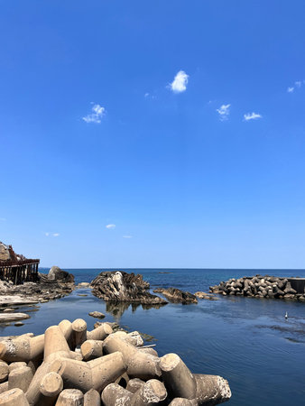 Rocky coast of the sea under the blue sky with white clouds